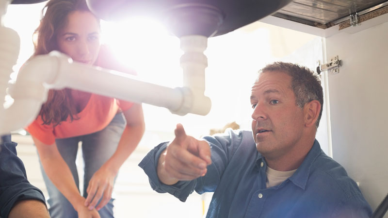 Plumber showing client what they found during a plumbing system inspection